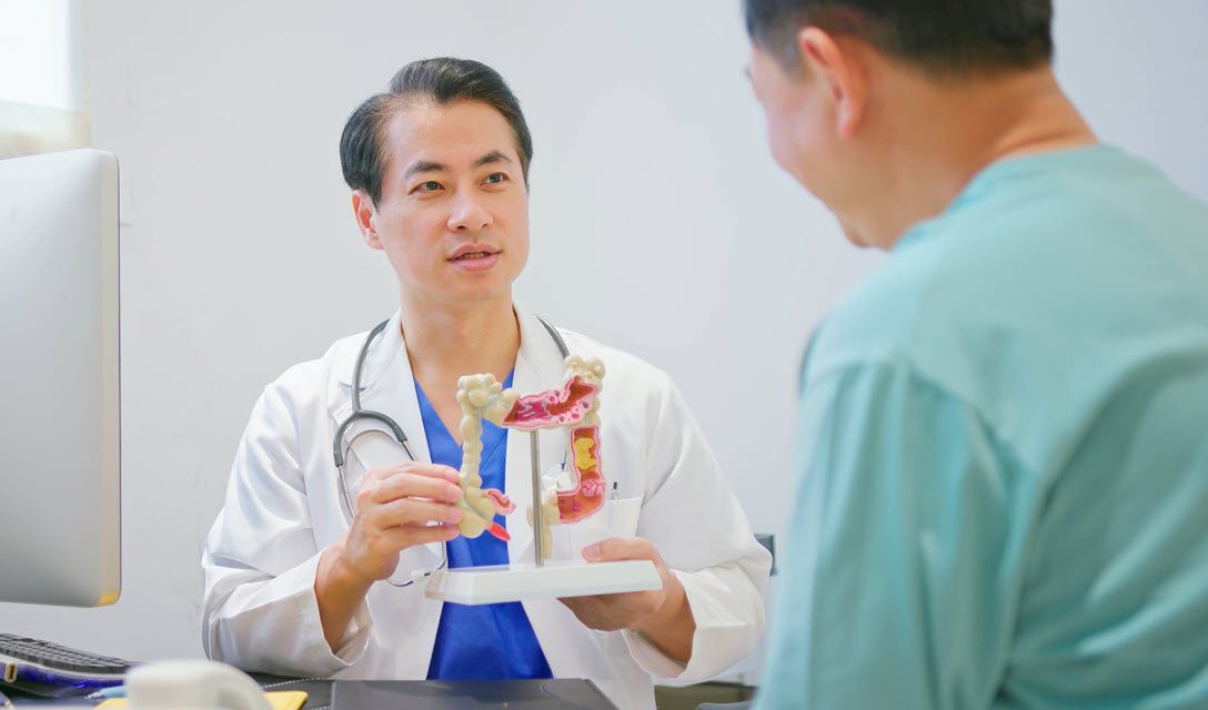 Provider showing model of colon to patient